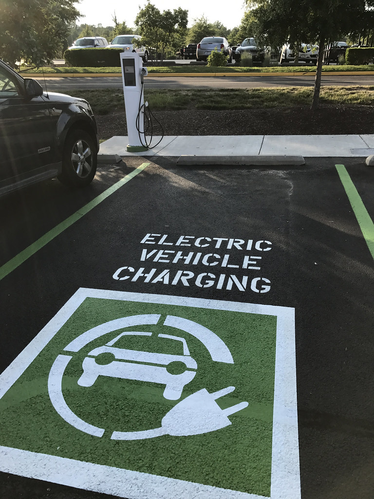 Decorative image of an EV charging spot in a parking lot.